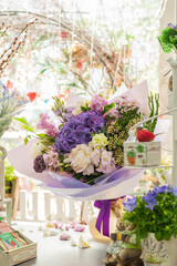 Fototapeta na wymiar Flower bouquet with purple hydrangea. Stylish bouquet as a gift. Small business. Flower sales. Selective focus.