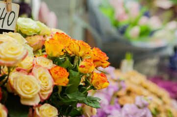 Yellow and red roses in the window of a flower shop. Flowers in the refrigerator. Small business. Selective focus.