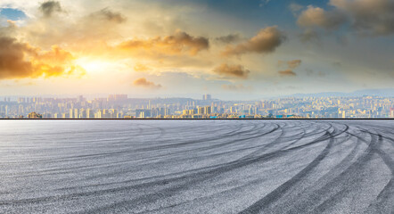 Empty racing track road and chongqing skyline with buildings at sunset.