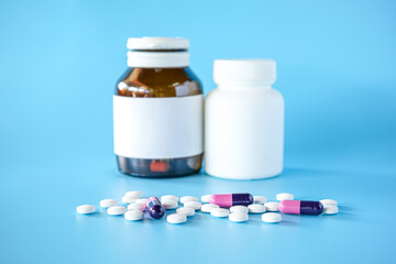 pill bottle with teblets pills on blue background with selective focus