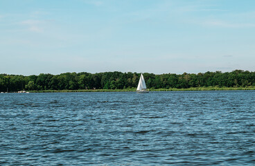 A lone sail boat on beautiful lake.