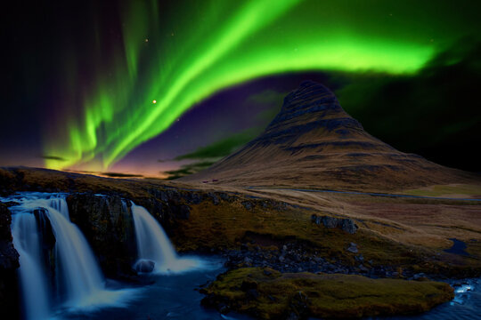 Scenic landscape of Kirkjufell with Green Aurora Light at Sunset, Iceland