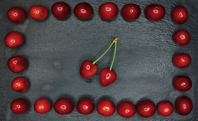 cherry with a tail framed from cherry on a black background