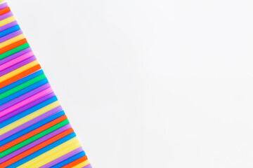 Fototapeta na wymiar A strip of many plastic colored straws arranged in a row. Isolated
