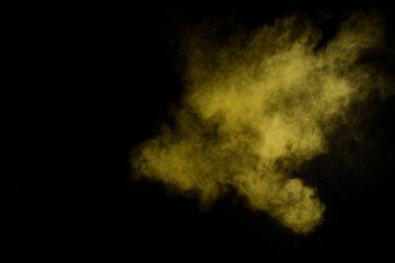 Yellow powder explosion on black background. Colored powder cloud. Colorful dust explode. Paint  Holi.