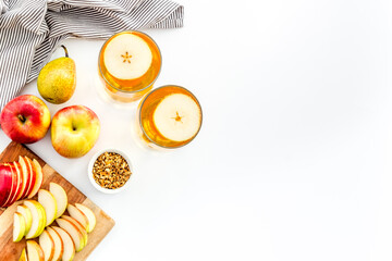 Glasses of beer with apple and peer on white table top view copy space