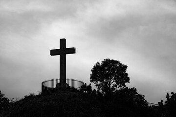 Czarno-Biały widok na krzyż na wzgórzu Gellerta w Budapeszcie na tle zachmurzonego nieba - obrazy, fototapety, plakaty