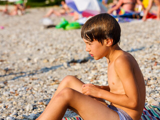 Child on vacation tans on the beach