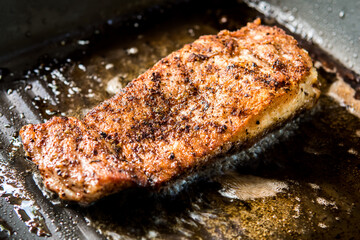 Frying pork steak in pan , in door  Chiangmai  Thailand