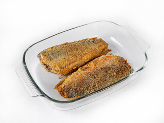 Fried breaded fish lies in a glass bowl on a white background