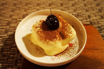Close up dish of Tiramisu -Italian dessert made of Mascarpone custard layered with whipped cream ,rum and coffee soaked ladyfingers