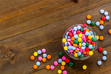 Colorful sweets on white wooden table top-down space for text