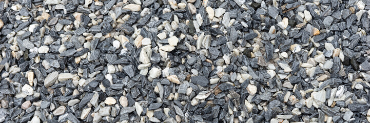 Decorative black and white pebble stones as background. Panoramic picture