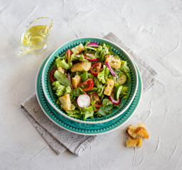 Fattoush salad, Middle Eastern cuisine. Green vegetables, herbs, tomato, radish and pieces of toasted pita bread. Lebanese food. Top view