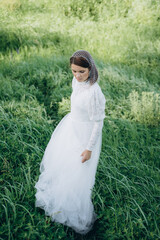 beautiful woman in long white dress posing in the field 