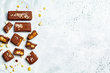 Raw vegan chocolate with caramel bars, white background, top view, copy space. Healthy desserts concept.