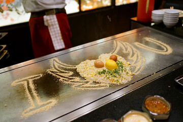 Egg Fried Rice - Chef cooking on teppanyaki grill plate, Prepared for Teppanyaki style, Enjoy the spectacle of cooked to perfection by chef, Traditional Japenese steakhouse.