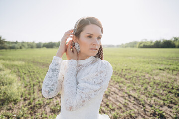 bride in white dress standing in green area