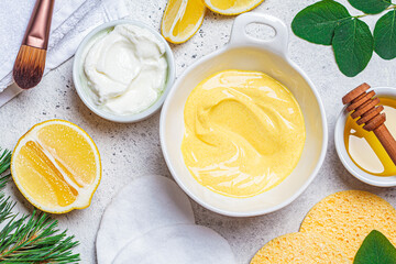 Preparation of turmeric face mask with honey and yogurt in white bowl. Skincare concept.