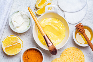 Preparation of turmeric face mask with honey and yogurt in white bowl. Skincare concept.