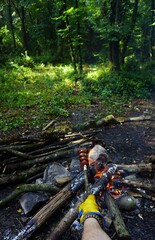 Cooking banger (sujuk) on campfire in forest, Camping in nature