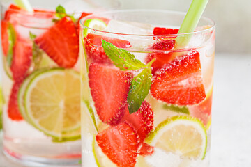 Detox sassy water with strawberries and lime in glasses. Healthy eating concept.