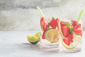 Detox sassy water with strawberries and lime in glasses. Healthy eating concept.