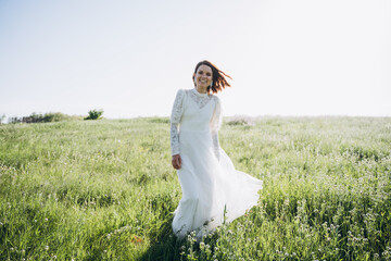 Fototapeta na wymiar bride in white dress standing in green area