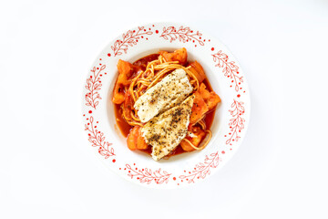 close up of spaghetti with baked fish in tomato sauce
