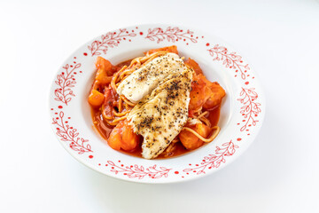 close up of spaghetti with baked fish in tomato sauce