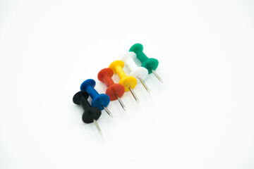 colored pushpins in line on a white background