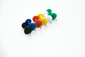 colored pushpins in line on a white background