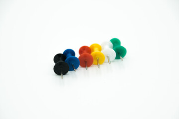 colored pushpins in line on a white background