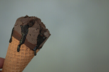 Cone of chocolate ice cream and chocolate sauce