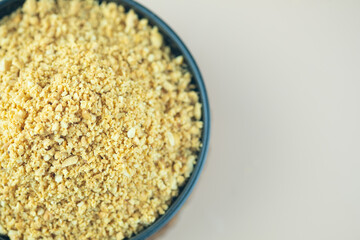 A black bowl filled with peanut powder for put in food