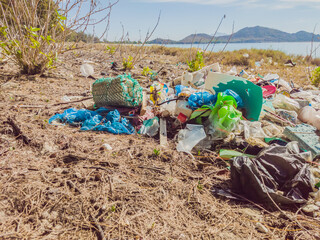 Spilled garbage on the beach. Empty used plastic, boxes and ropes. Dirty sea sandy shore. Environmental pollution. Ecological problem. Ocean Dumping - Total pollution