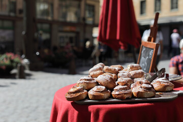  Pastry in focus on a tray near restaurant  on the street, people are blurred