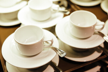 Many white glasses caps for coffee and tea on the tray 