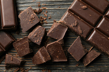 Chocolate pieces on wooden background, close up