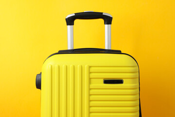 Color travel bag on yellow background, close up