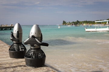 Two Diver Propulsion Vehicles on wood pier on Caribbean ocean beach © Naz