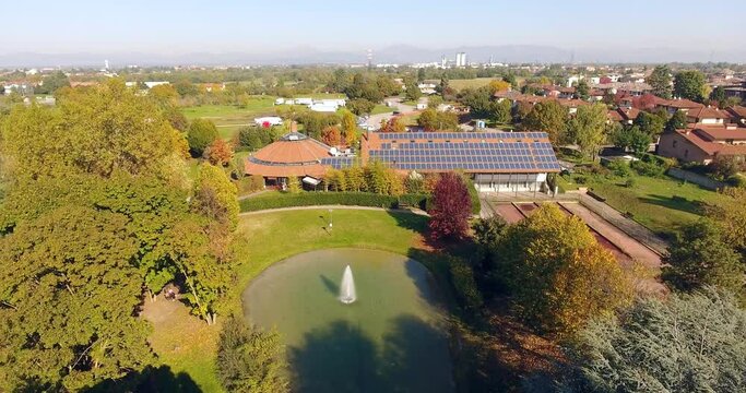 Aerial over a building with solar panels in a city park