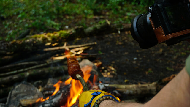 Photographing camping food, cooking on campfire in forest