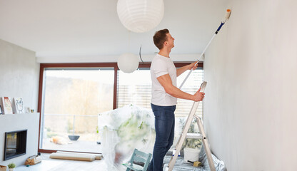 Mann als Maler beim Wand streichen