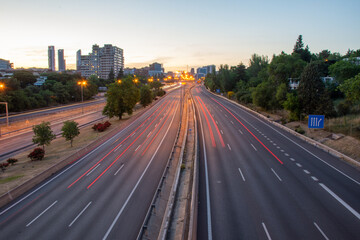 Panoramic view of M30 motorway, at sunset, with red trails of car lights, in Madrid, Spain, horizontal