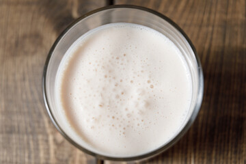 Probiotic cold fermented dairy drink kefir on wooden background.