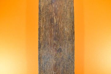 Stara brązowa deska na pomarańczowym tle. 