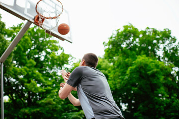 Two young men playing basketball in the park. Friends having a friendly match outdoors	