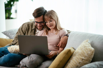 Young couple watching movie on lap top. Loving couple enjoying at home.	
