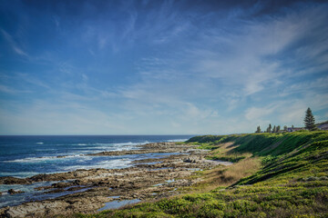 Naklejka premium A wide landscape photo of a rocky coast during low tide.